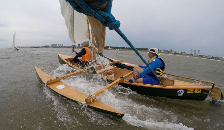 The Eureka canoe sailing with drop-in outriggers