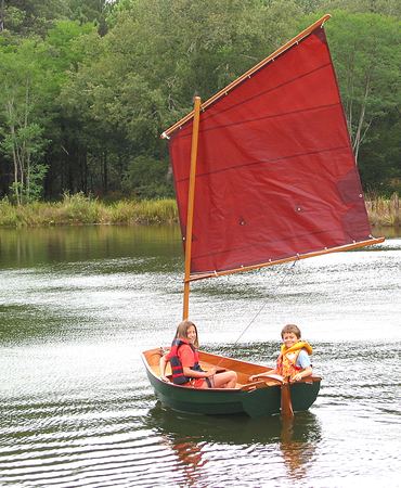 Children messing about learning to sail in a home made Eastport pram dinghy