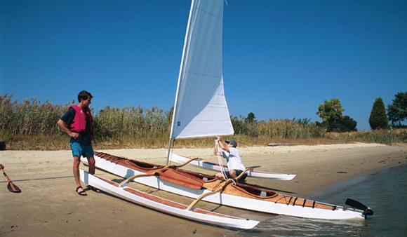 Sailing a triple wooden kayak with outriggers