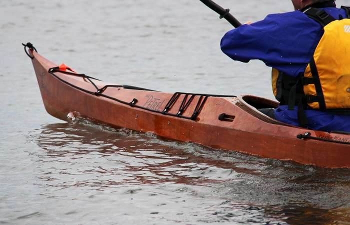 The deck shape of the Petrel wooden sea kayak provides knee room while remaining low
