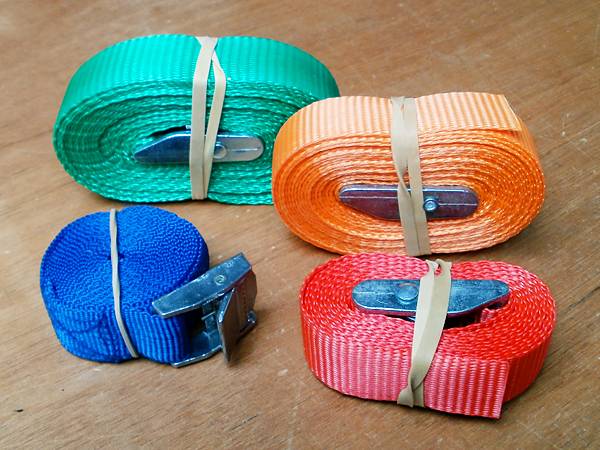 Webbing straps with cam buckles for securely lashing a boat to a roof rack or kayak trolley