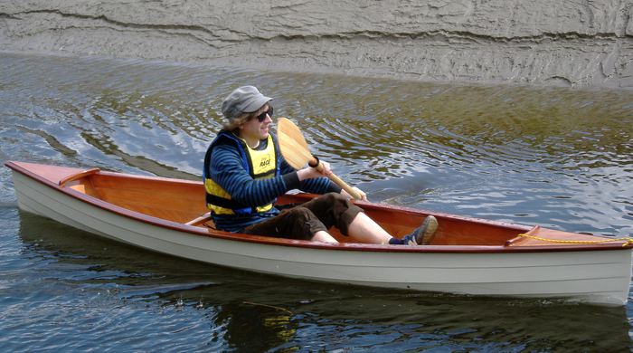 Single seat open canoe paddled by the proud builder