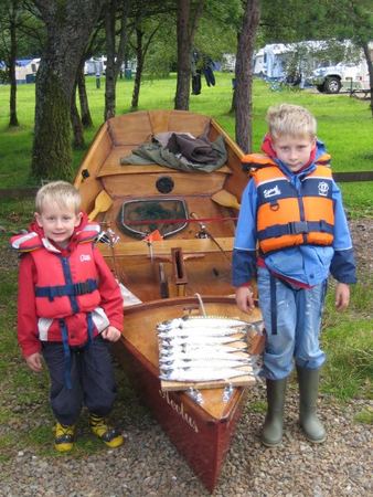 Boys catch of fish from their home made boat