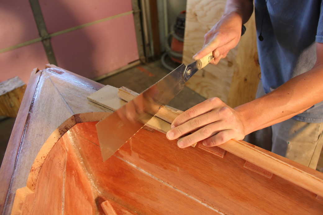 Cut the inwale to length while protecting the boat with some scrap wood