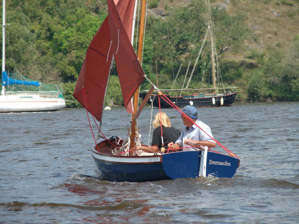 Stern of a home made clinker boat disappears into the distance