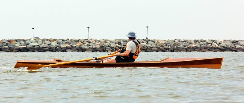 The Noank Pulling Boat is an efficient wooden sculling boat suitable for open water expeditions, using a drop-in sliding seat rowing unit