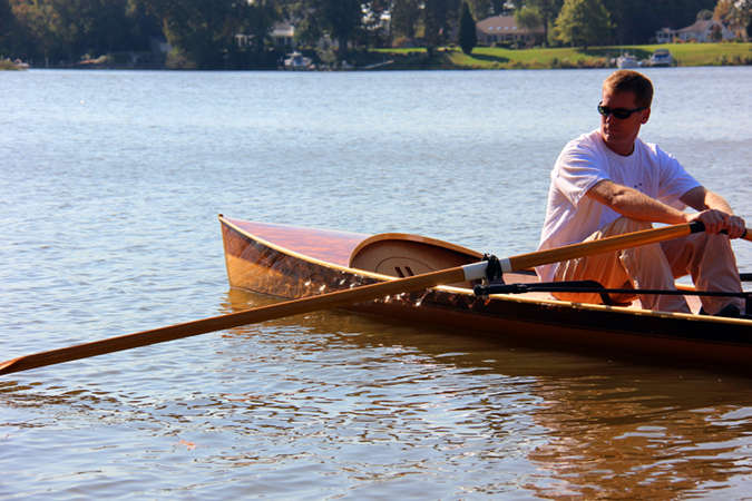 The Noank Pulling Boat is an efficient wooden sculling boat suitable for open water expeditions, using a drop-in sliding seat rowing unit