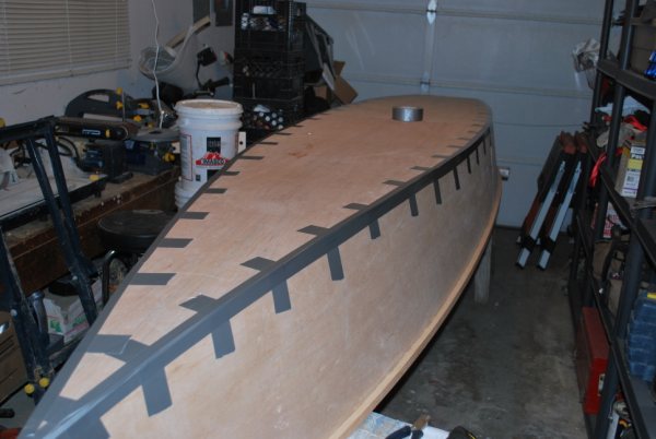 Plywood panels fastened with duct tape for simple canoe construction