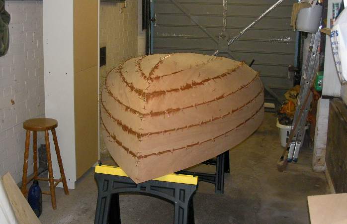 Epoxy filleting the joints on a wooden dinghy