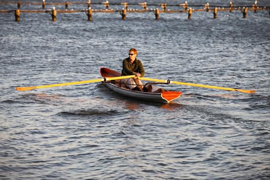 CLC tandem wooden wherry being rowed by one person