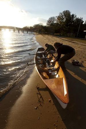 Launching a tandem double seat wooden rowing boat