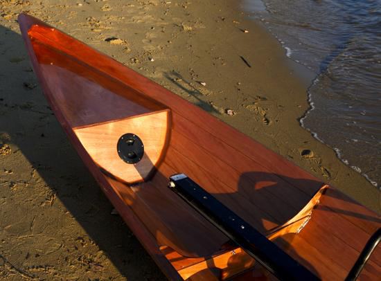 Shiny bow of a wooden wherry rowing boat that is built for two